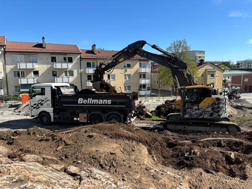 Grävmaskin lastar en lastbil med flak